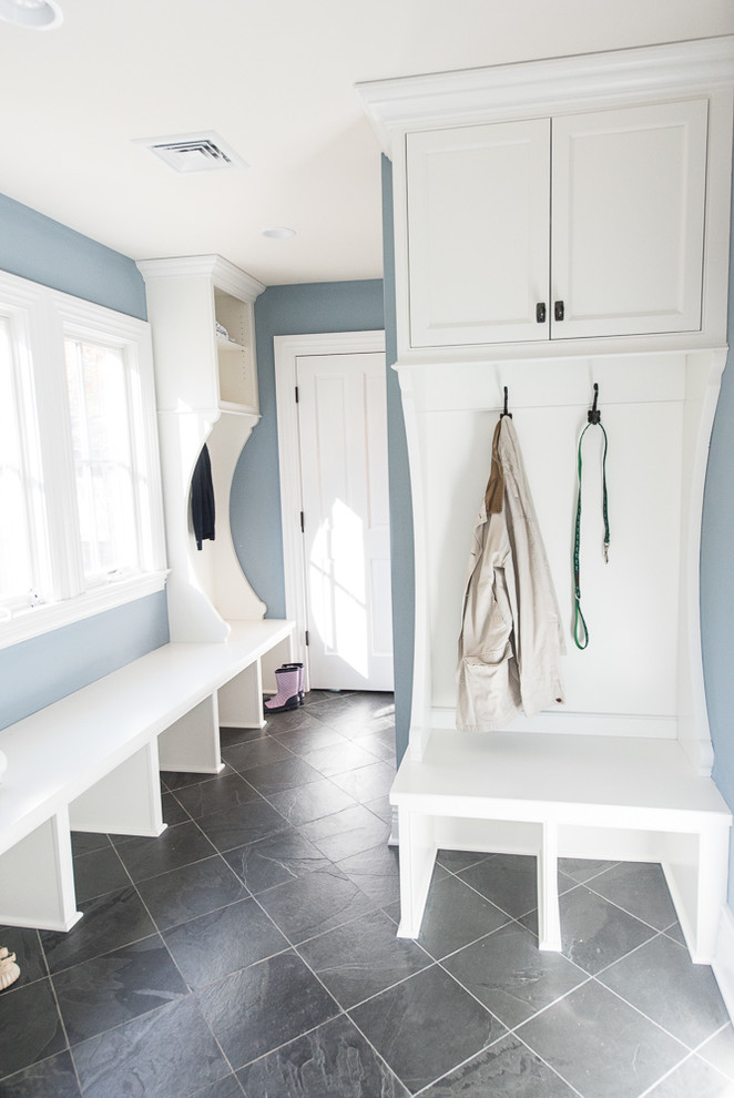 Photo of a mid-sized country mudroom in New York with blue walls, slate floors, a single front door and a medium wood front door.