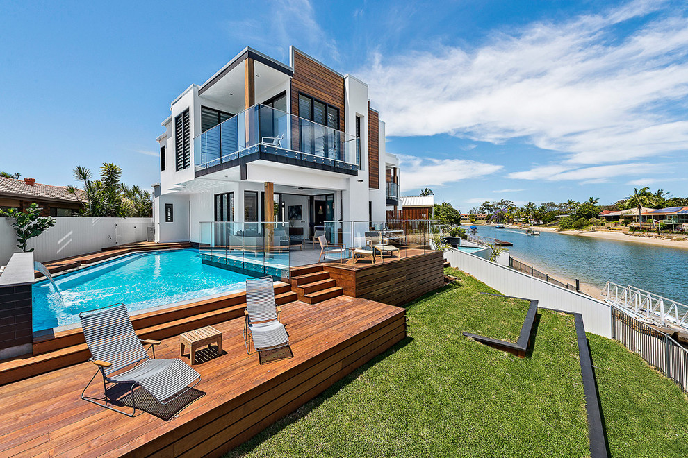 This is an example of a mid-sized contemporary backyard custom-shaped pool in Brisbane with a water feature.