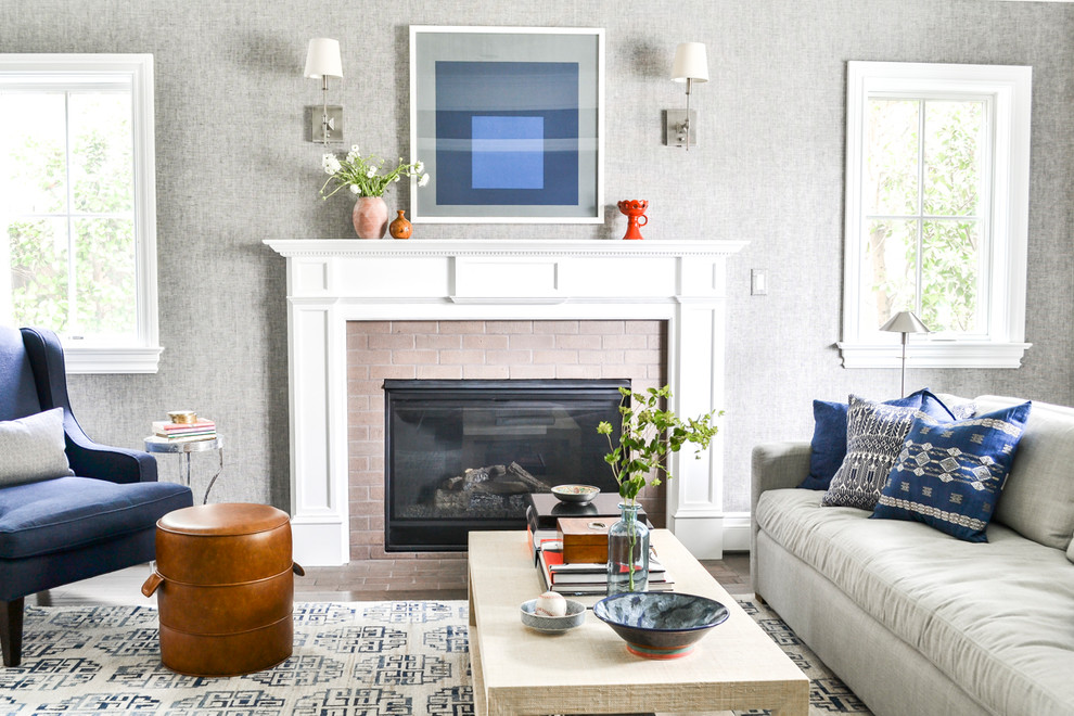 This is an example of a beach style living room in Los Angeles with grey walls, a standard fireplace, a brick fireplace surround and no tv.