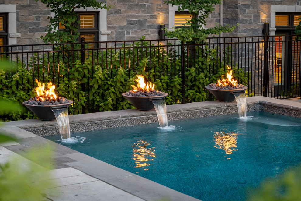 Pool fountain - mid-sized transitional backyard stamped concrete and rectangular pool fountain idea in Toronto