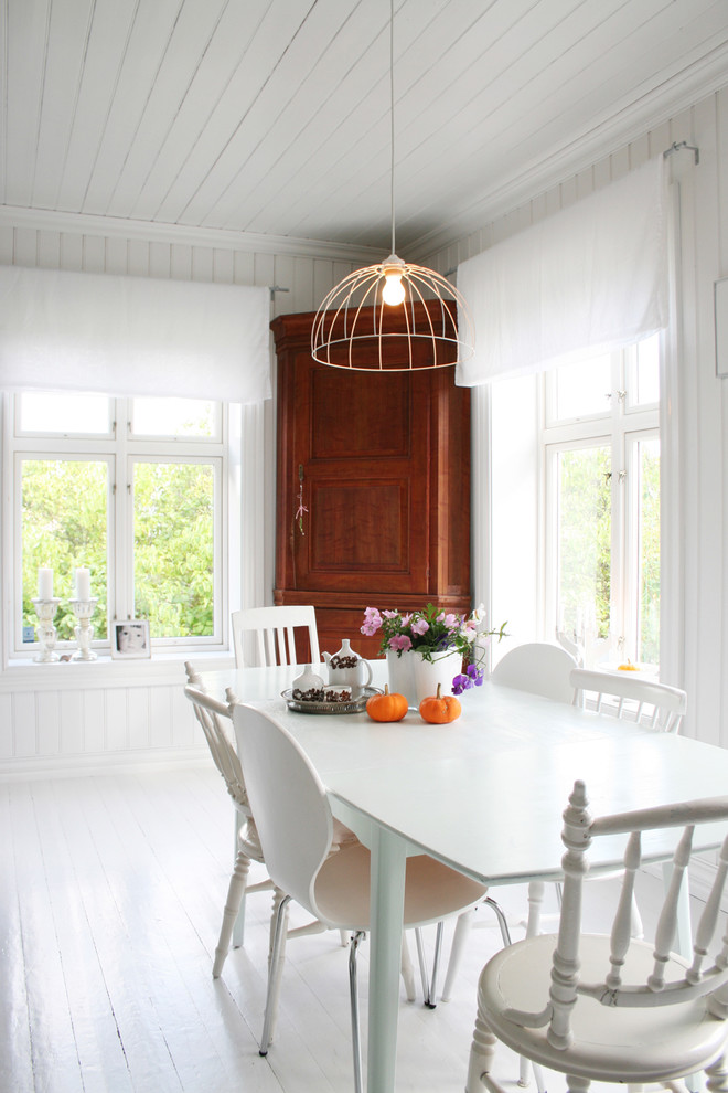 Scandinavian dining room in Other with white walls, painted wood floors and white floor.