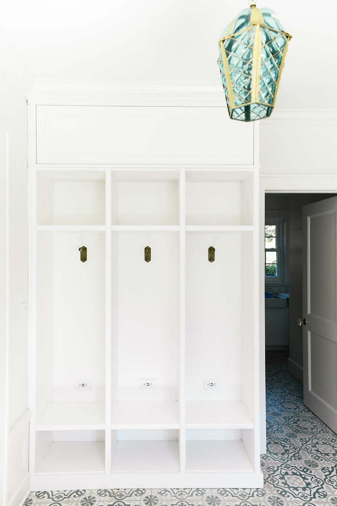 This is an example of a large transitional mudroom in Tampa with white walls, a single front door and multi-coloured floor.