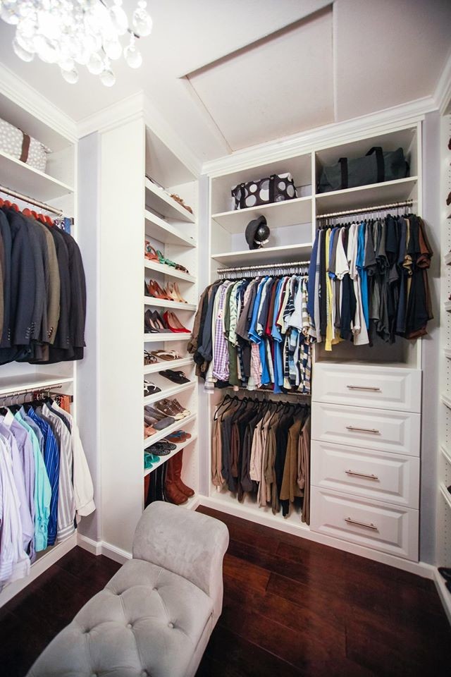 Photo of a mid-sized modern gender-neutral walk-in wardrobe in Los Angeles with flat-panel cabinets, white cabinets and dark hardwood floors.