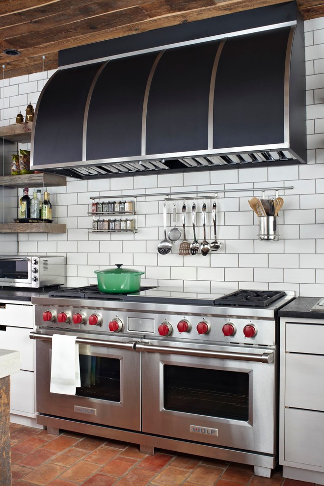 Inspiration for a transitional kitchen in Chicago with flat-panel cabinets, white cabinets, white splashback, subway tile splashback and stainless steel appliances.
