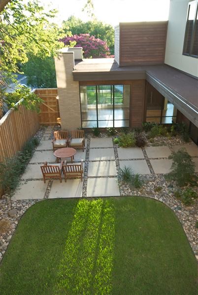 Photo of a large modern courtyard patio in Dallas with natural stone pavers and no cover.