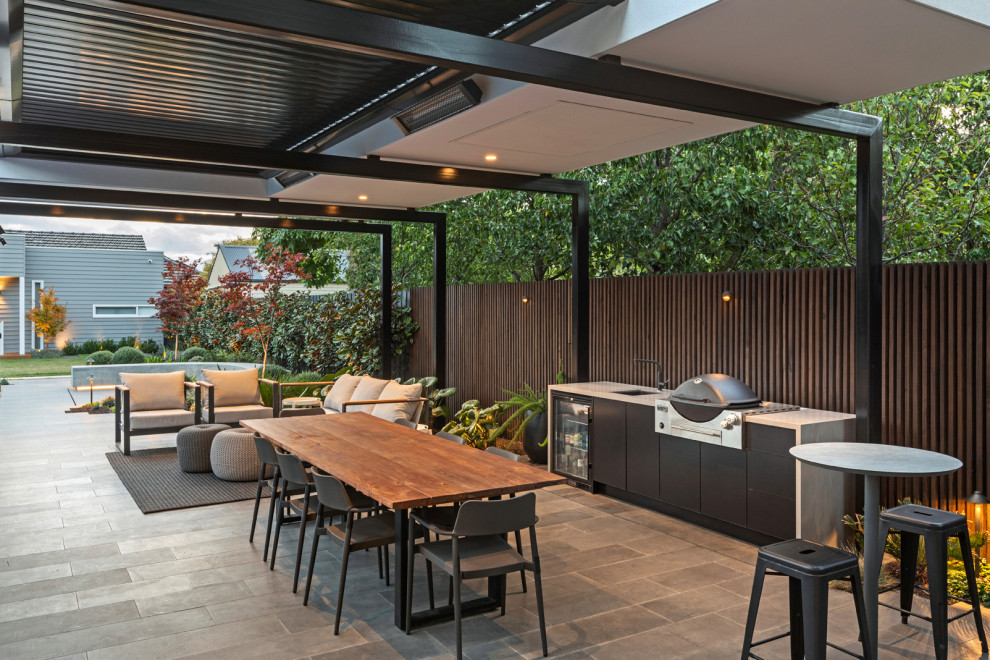 Modelo de patio contemporáneo grande en patio trasero con cocina exterior, adoquines de piedra natural y cenador