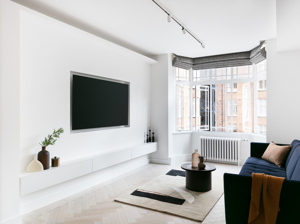 This is an example of a mid-sized contemporary formal open concept living room in London with white walls, light hardwood floors, a built-in media wall and beige floor.