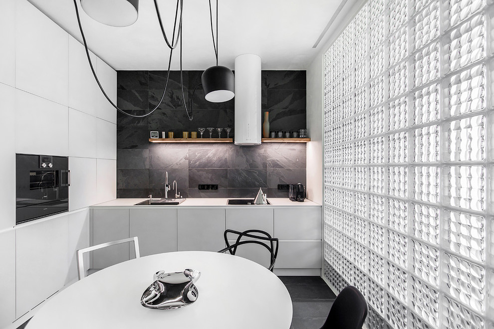 This is an example of a contemporary l-shaped open plan kitchen in Moscow with a drop-in sink, flat-panel cabinets, black splashback, black appliances and no island.