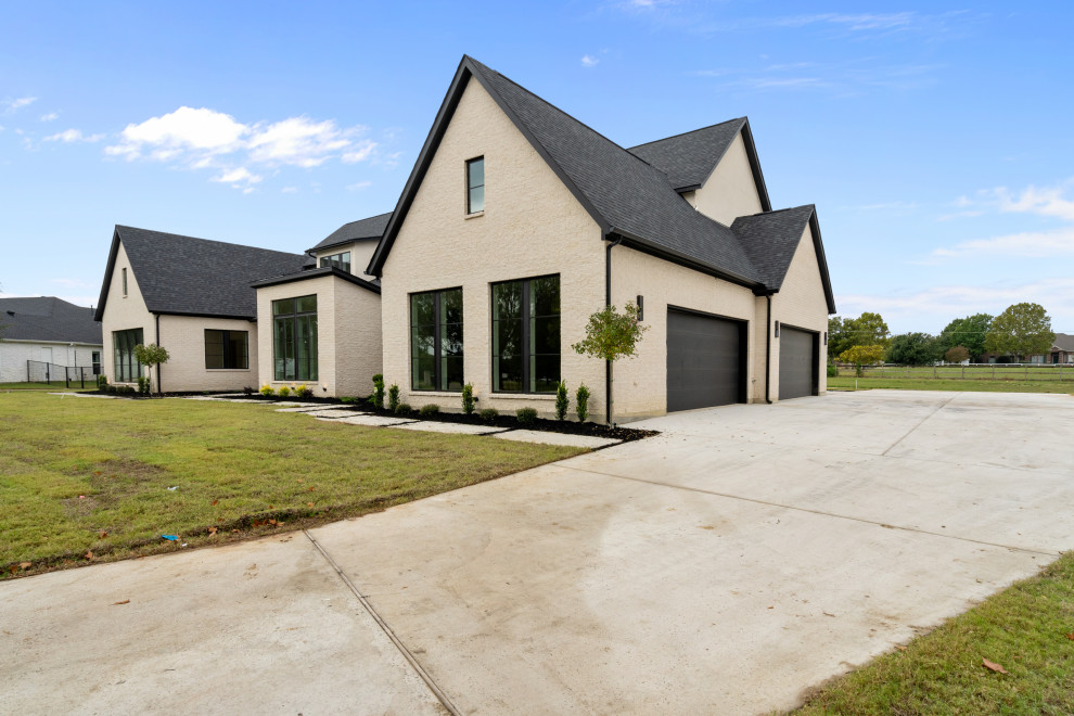 Large minimalist white two-story stone exterior home photo in Dallas with a shingle roof and a black roof