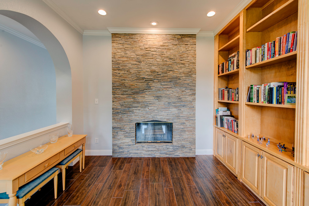 Photo of a mid-sized contemporary living room in Dallas with a library, medium hardwood floors, a standard fireplace and a stone fireplace surround.