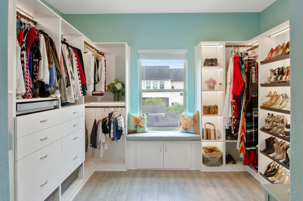This is an example of a large transitional gender-neutral dressing room in Houston with flat-panel cabinets, white cabinets, porcelain floors and grey floor.