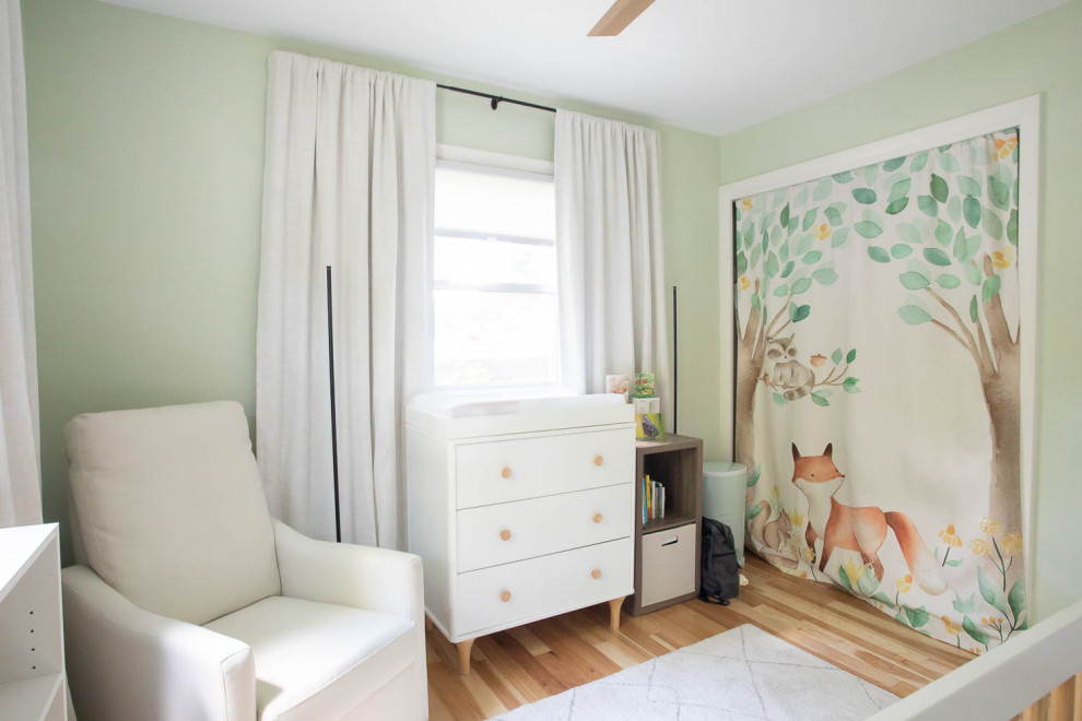 Inspiration for a small contemporary gender-neutral nursery with green walls and light hardwood floors.