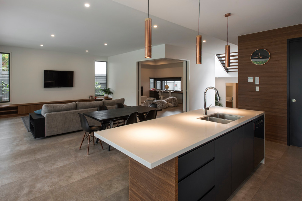 This is an example of a contemporary galley open plan kitchen with black cabinets, window splashback, ceramic floors, grey floor and white benchtop.