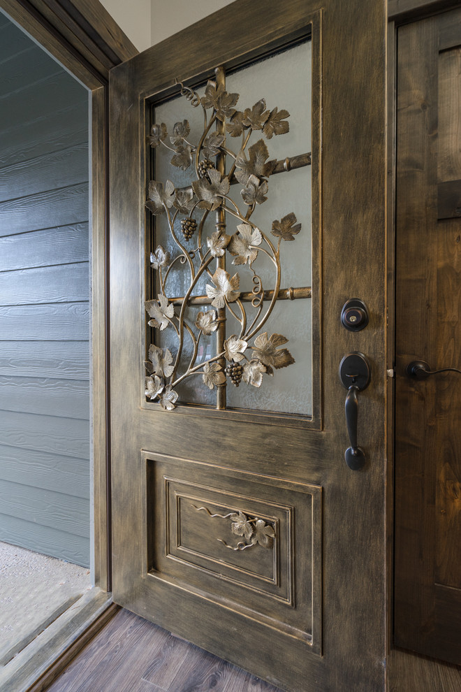 Inspiration for a large rustic laminate floor and brown floor front door remodel with a dark wood front door