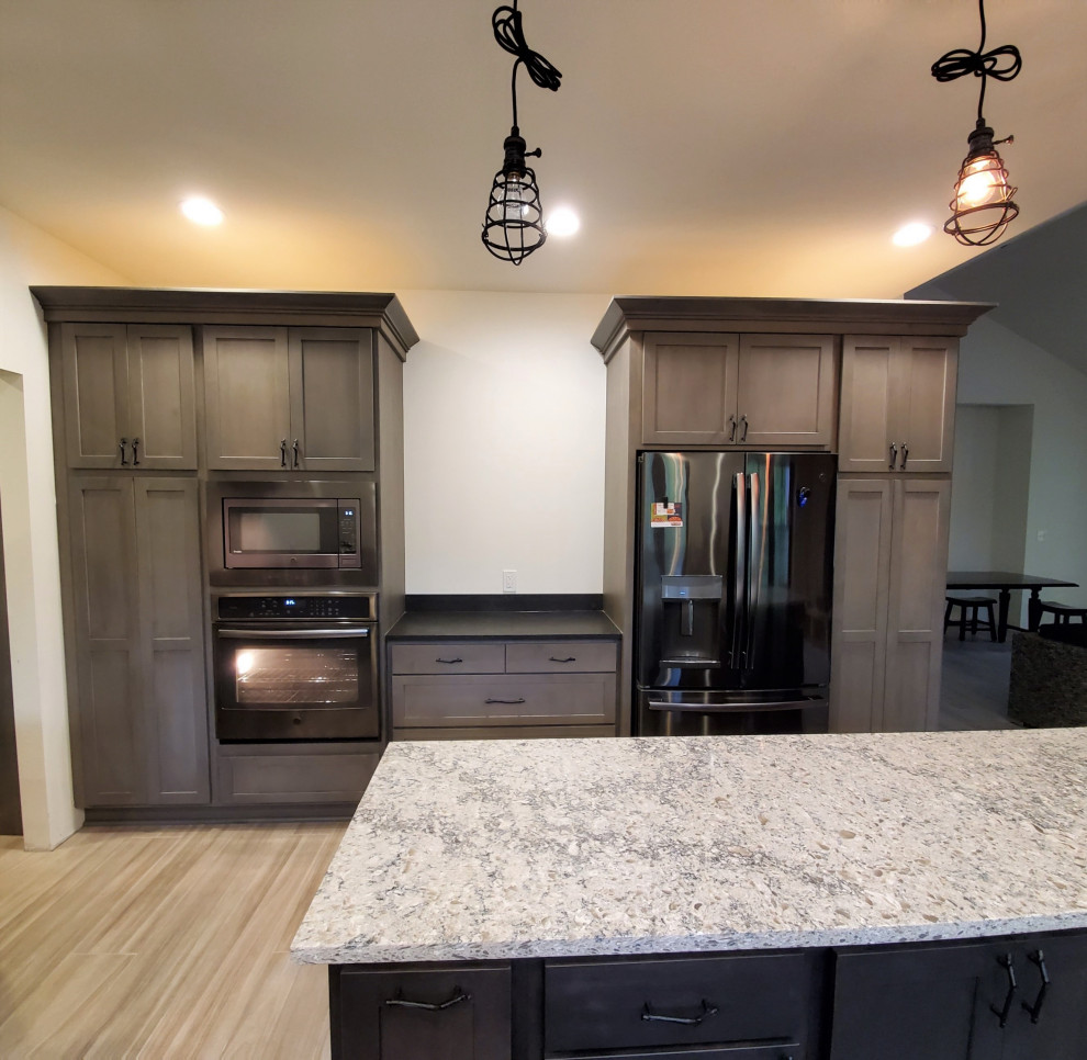 Example of a mid-sized transitional porcelain tile and gray floor kitchen design with shaker cabinets, gray cabinets, quartz countertops, stainless steel appliances, an island and white countertops