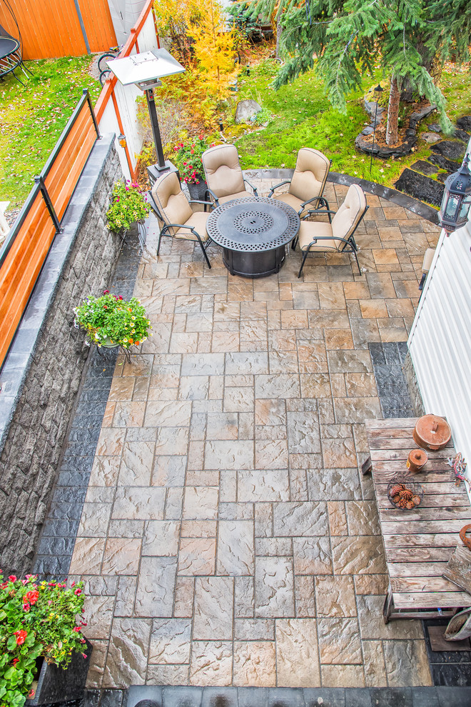 Inspiration for a small country courtyard patio in Calgary with a fire feature and concrete pavers.