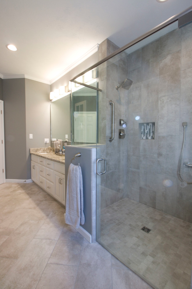 Walk-in shower - mid-sized transitional master gray tile and ceramic tile ceramic tile walk-in shower idea with an undermount sink, raised-panel cabinets, white cabinets, granite countertops, a two-piece toilet and gray walls