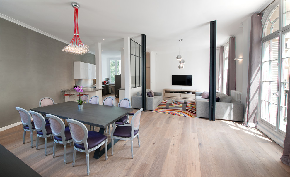Photo of a contemporary open plan dining in Paris with grey walls and light hardwood floors.