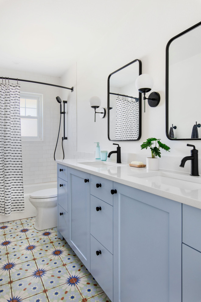 Transitional bathroom in Austin with shaker cabinets, blue cabinets, an alcove tub, a shower/bathtub combo, white tile, subway tile, white walls, an undermount sink, multi-coloured floor, white benchtops, a double vanity and a built-in vanity.