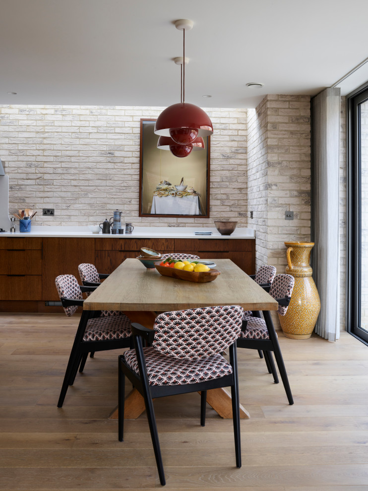 Inspiration for a midcentury dining room in Other with light hardwood floors and brick walls.