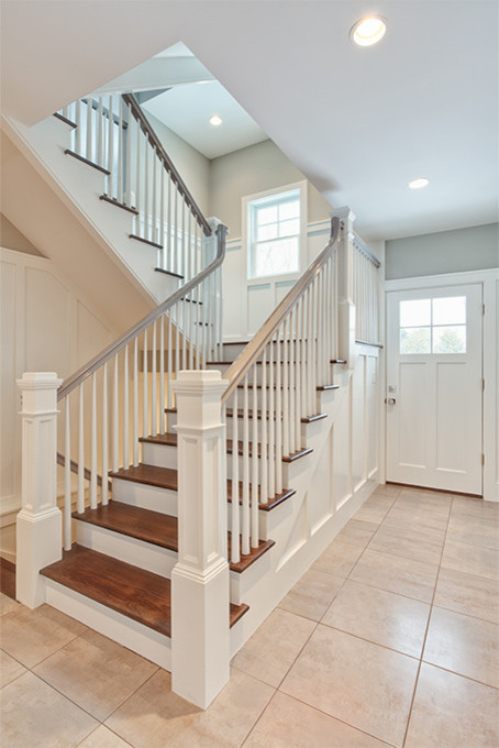 Example of a large transitional wooden u-shaped wood railing staircase design with painted risers