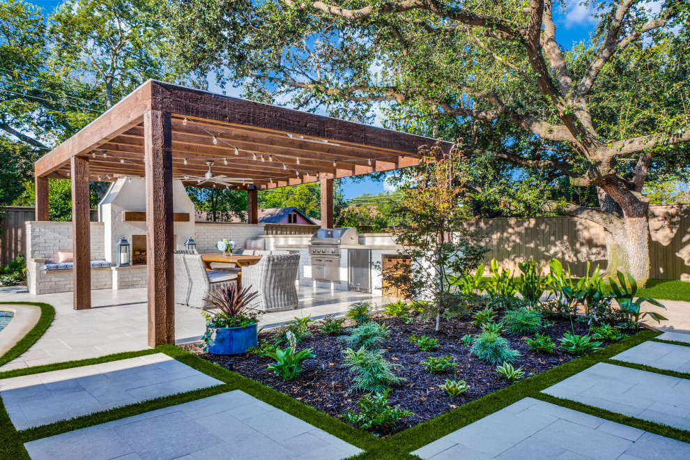 Design ideas for an expansive eclectic backyard patio in Dallas with with fireplace and a pergola.