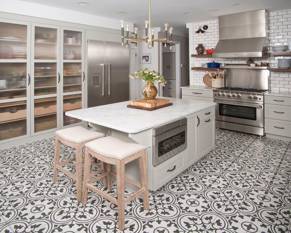 Eat-in kitchen - mid-sized transitional u-shaped ceramic tile and multicolored floor eat-in kitchen idea with a farmhouse sink, marble countertops, white backsplash, subway tile backsplash, stainless steel appliances, an island, gray cabinets and shaker cabinets