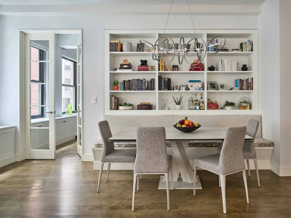 Photo of a mid-sized transitional open plan dining in New York with white walls, medium hardwood floors and brown floor.