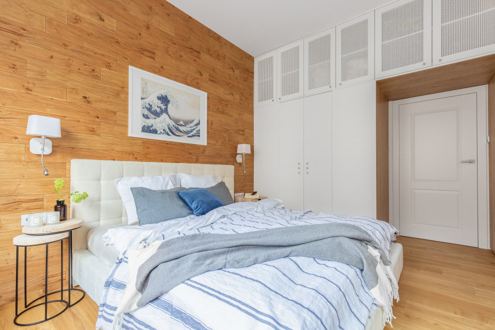 Cette photo montre une chambre parentale tendance en bois de taille moyenne avec un mur blanc, un sol en bois brun, aucune cheminée et un sol marron.