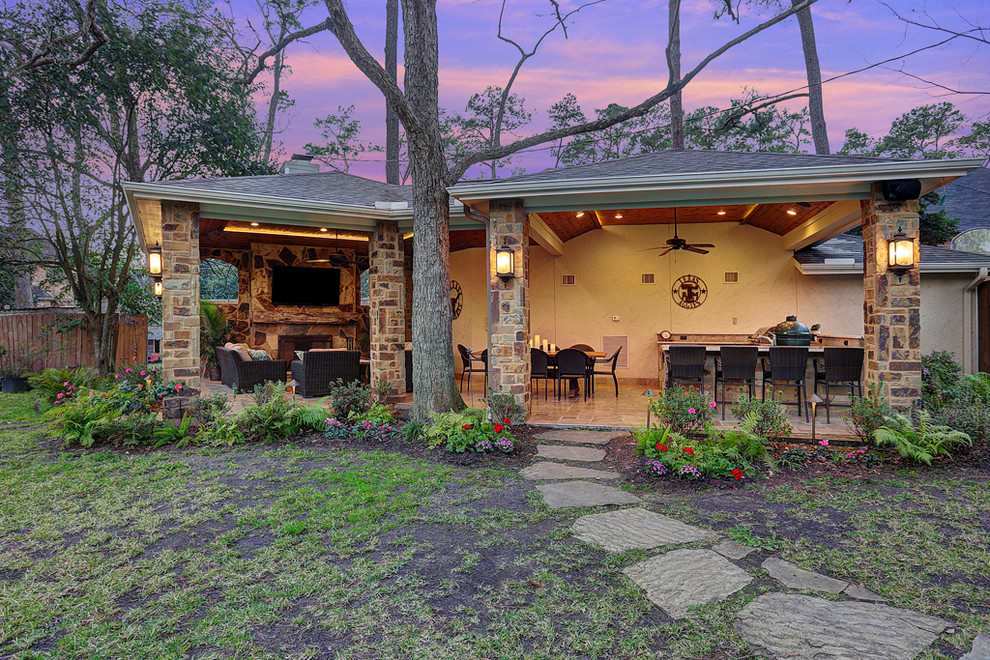 Mid-sized country backyard patio in Houston with an outdoor kitchen, tile and a roof extension.