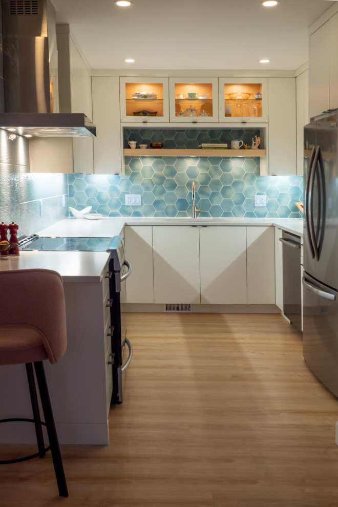 オタワにあるお手頃価格の小さなエクレクティックスタイルのおしゃれなキッチン (アンダーカウンターシンク、フラットパネル扉のキャビネット、白いキャビネット、クオーツストーンカウンター、青いキッチンパネル、磁器タイルのキッチンパネル、シルバーの調理設備、クッションフロア、ベージュの床、白いキッチンカウンター) の写真