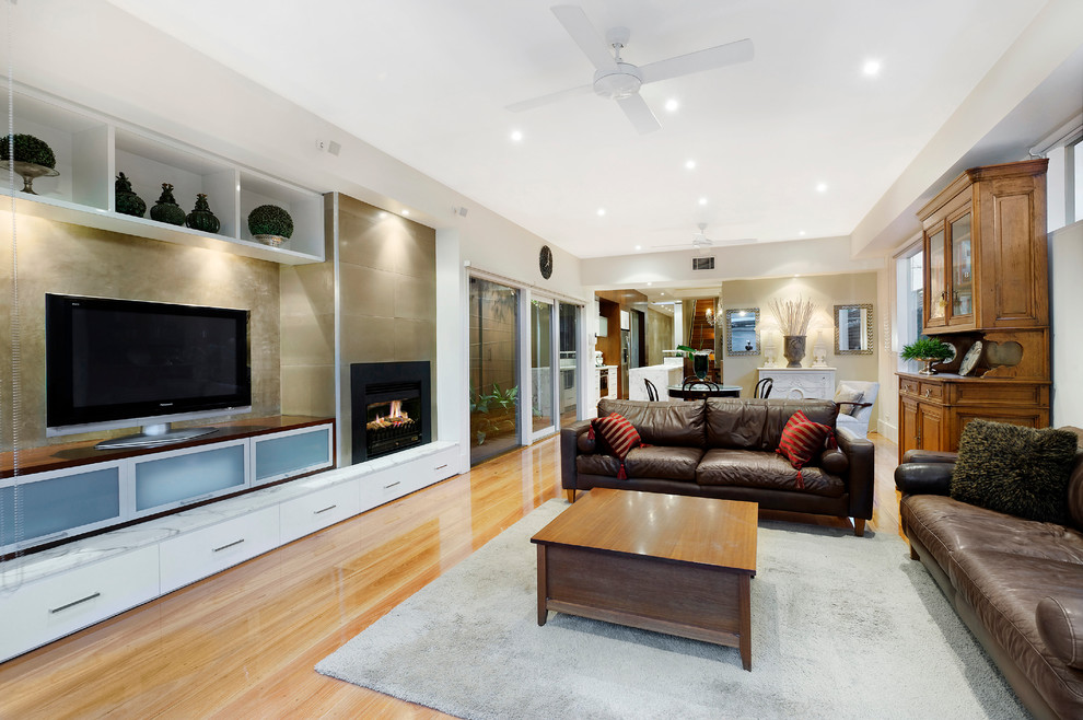 Contemporary living room in Melbourne with medium hardwood floors and a freestanding tv.