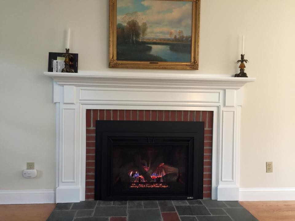 This is an example of a mid-sized traditional formal living room in Boston with yellow walls, medium hardwood floors, a standard fireplace, a brick fireplace surround, no tv and brown floor.