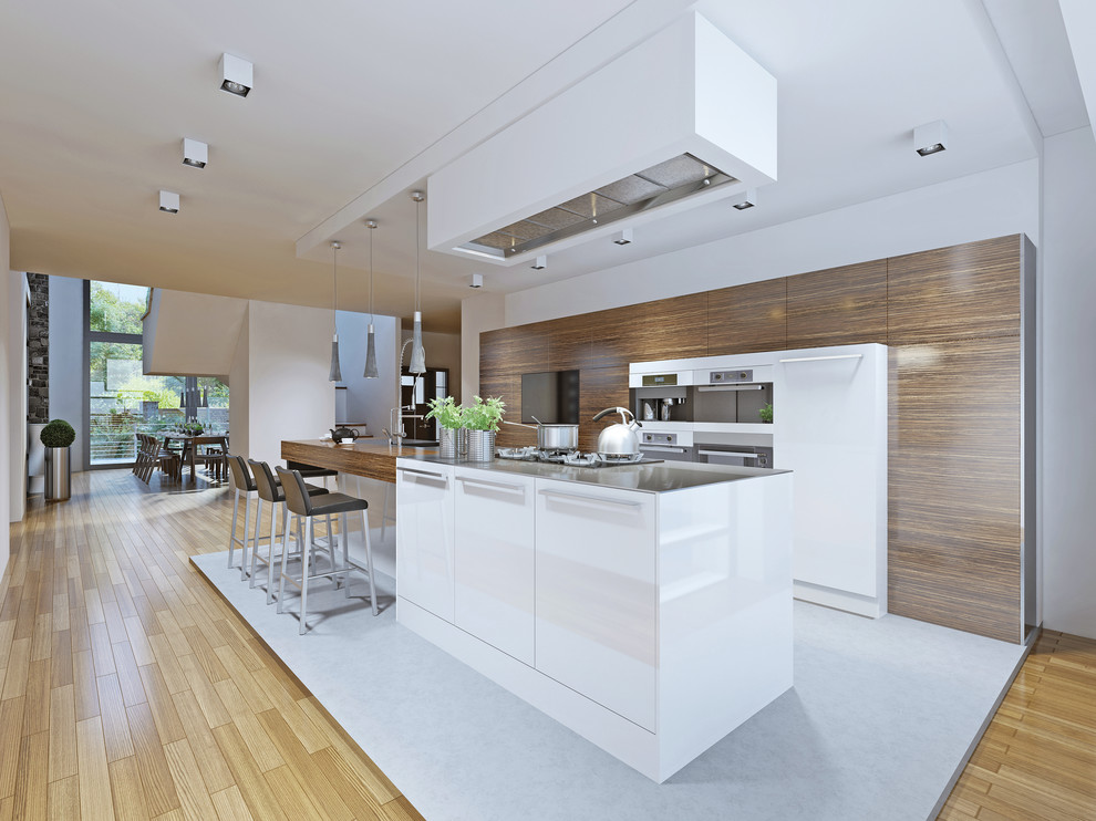 Photo of a mid-sized contemporary single-wall open plan kitchen in Sydney with an integrated sink, brown cabinets, wood benchtops, white splashback, glass sheet splashback, stainless steel appliances, light hardwood floors, a peninsula and brown floor.