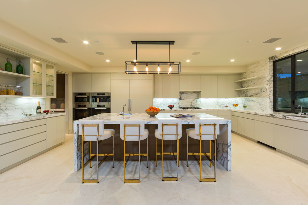Expansive contemporary u-shaped kitchen in Los Angeles with flat-panel cabinets, grey cabinets, white splashback, stone slab splashback and with island.