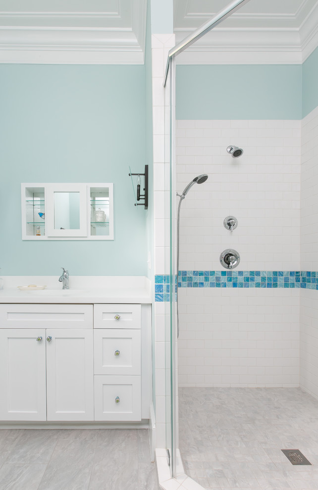 Medium sized mediterranean ensuite bathroom with shaker cabinets, white cabinets, a freestanding bath, an alcove shower, a one-piece toilet, white tiles, ceramic tiles, blue walls, a submerged sink, grey floors and a hinged door.