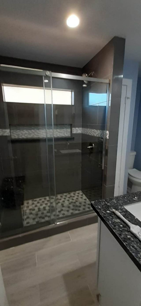 На фото: главная ванная комната среднего размера с фасадами в стиле шейкер, белыми фасадами, угловым душем, унитазом-моноблоком, белой плиткой, цементной плиткой, белыми стенами, полом из керамической плитки, консольной раковиной, мраморной столешницей, серым полом, открытым душем, черной столешницей, тумбой под одну раковину, встроенной тумбой и кессонным потолком с