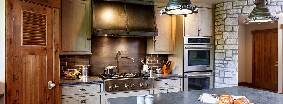 Large mountain style kitchen pantry photo in Austin with shaker cabinets, medium tone wood cabinets, solid surface countertops, brown backsplash, subway tile backsplash, stainless steel appliances and an island