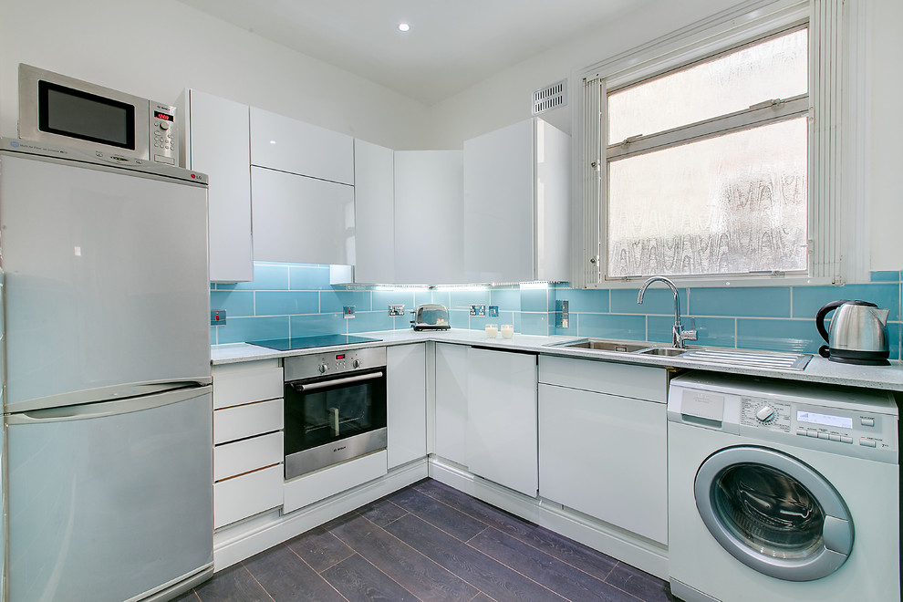 Inspiration for a small transitional l-shaped separate kitchen in London with a double-bowl sink, flat-panel cabinets, white cabinets, quartzite benchtops, blue splashback, ceramic splashback, stainless steel appliances, dark hardwood floors and no island.