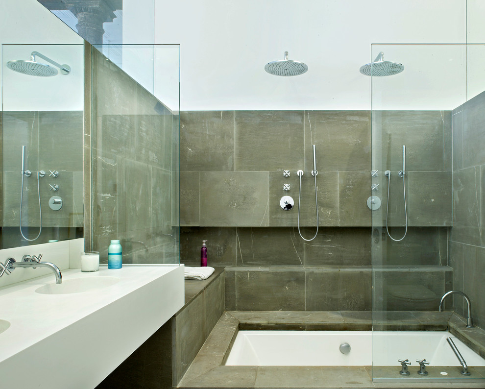 This is an example of a modern bathroom in New York with an integrated sink and stone tile.