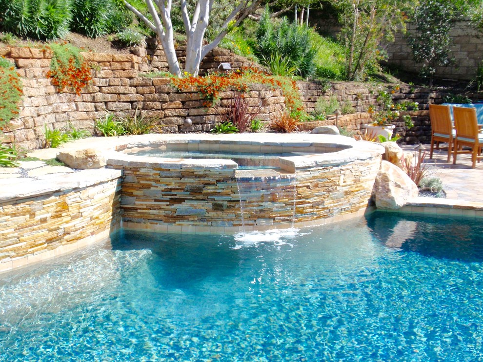 Mid-sized island style backyard concrete paver and custom-shaped natural hot tub photo in Orange County