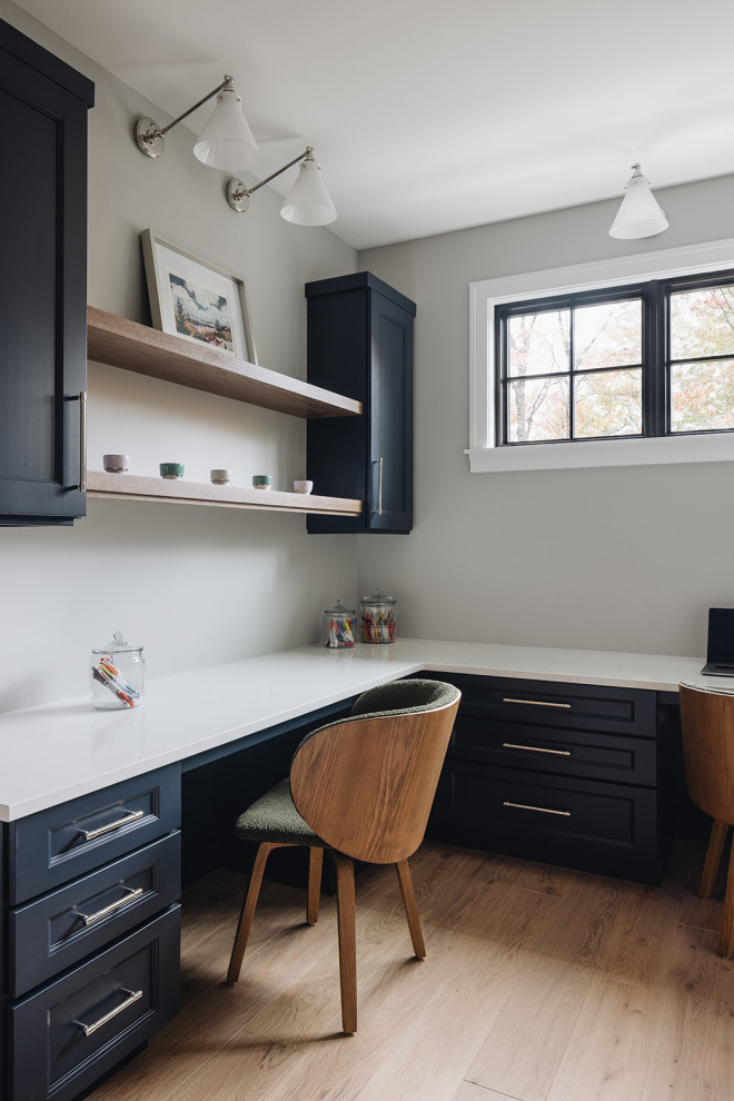 Imagen de despacho moderno grande con paredes grises, suelo de madera clara, escritorio empotrado y suelo beige