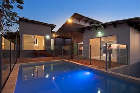 This is an example of a contemporary side yard rectangular aboveground pool in Sunshine Coast with natural stone pavers.