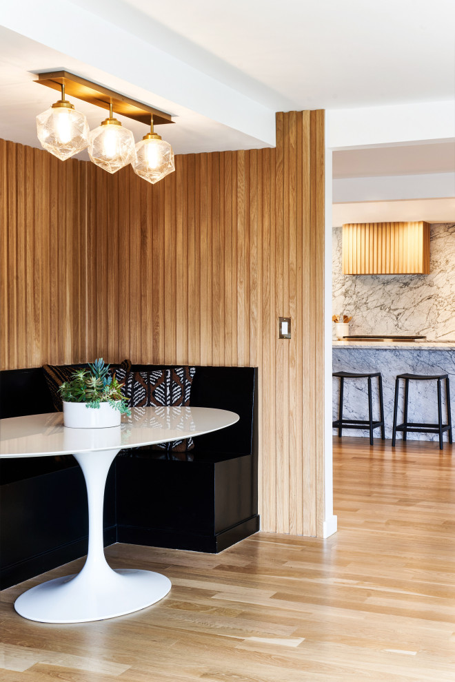 Photo of a midcentury dining room in Portland with beige walls, light hardwood flooring and wood walls.