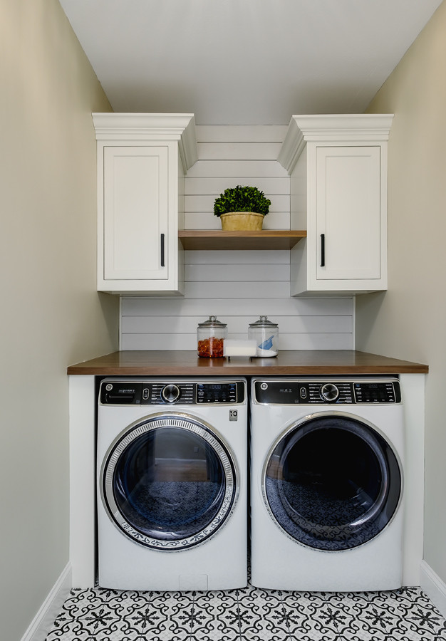Inspiration for a mid-sized transitional single-wall dedicated laundry room in Boston with recessed-panel cabinets, white cabinets, wood benchtops, white splashback, shiplap splashback, porcelain floors and multi-coloured floor.