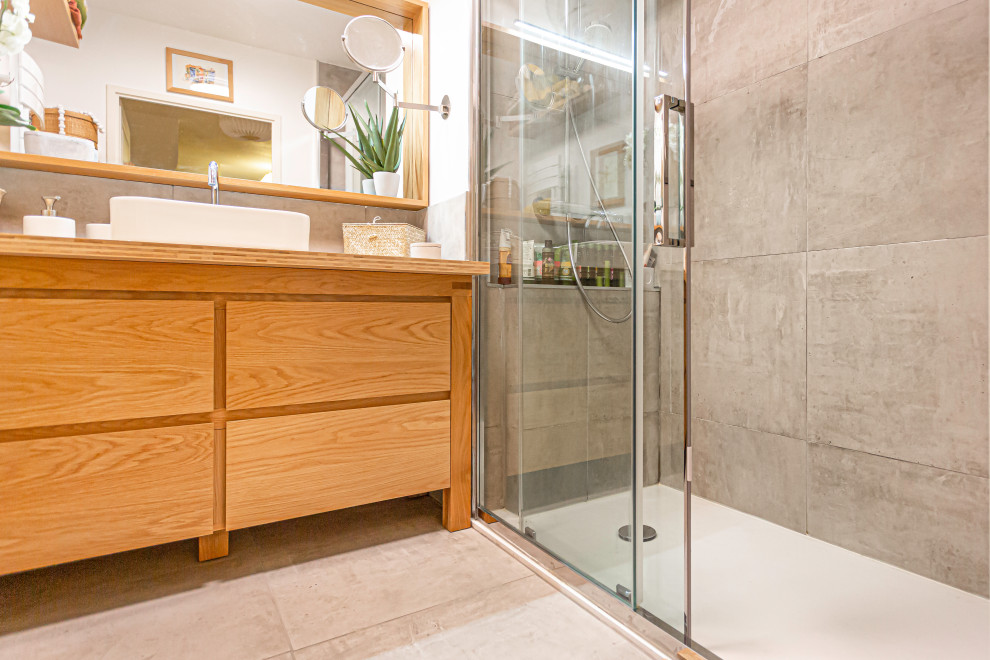 Inspiration för små moderna badrum med dusch, med skåp i ljust trä, en kantlös dusch, grå kakel, vita väggar, ett nedsänkt handfat, träbänkskiva, grått golv och dusch med skjutdörr