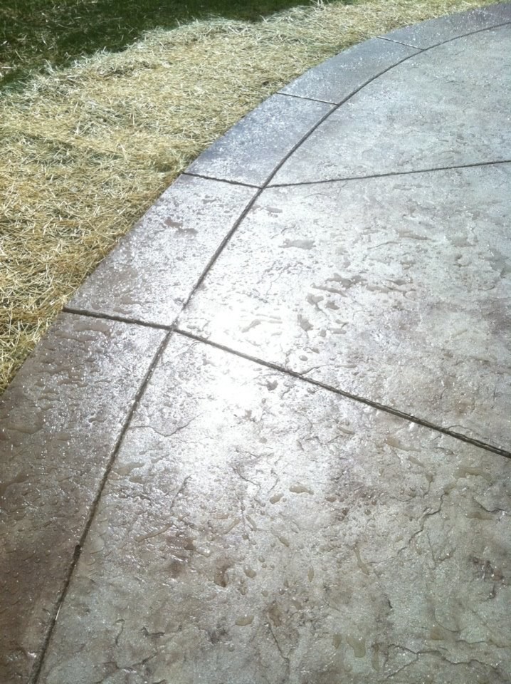 Design ideas for a large contemporary backyard patio in Indianapolis with stamped concrete.