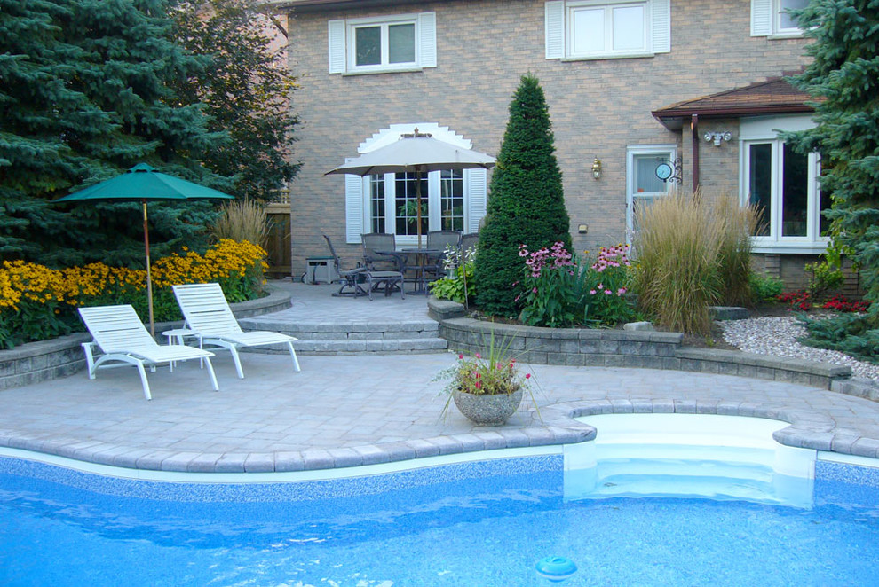 Inspiration for a mid-sized backyard concrete paver and freeform pool remodel in Toronto