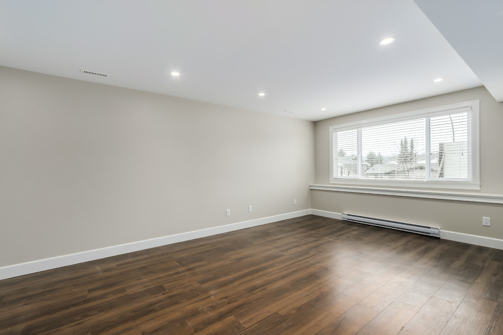Inspiration for a large transitional walk-out dark wood floor basement remodel in Vancouver with beige walls and no fireplace