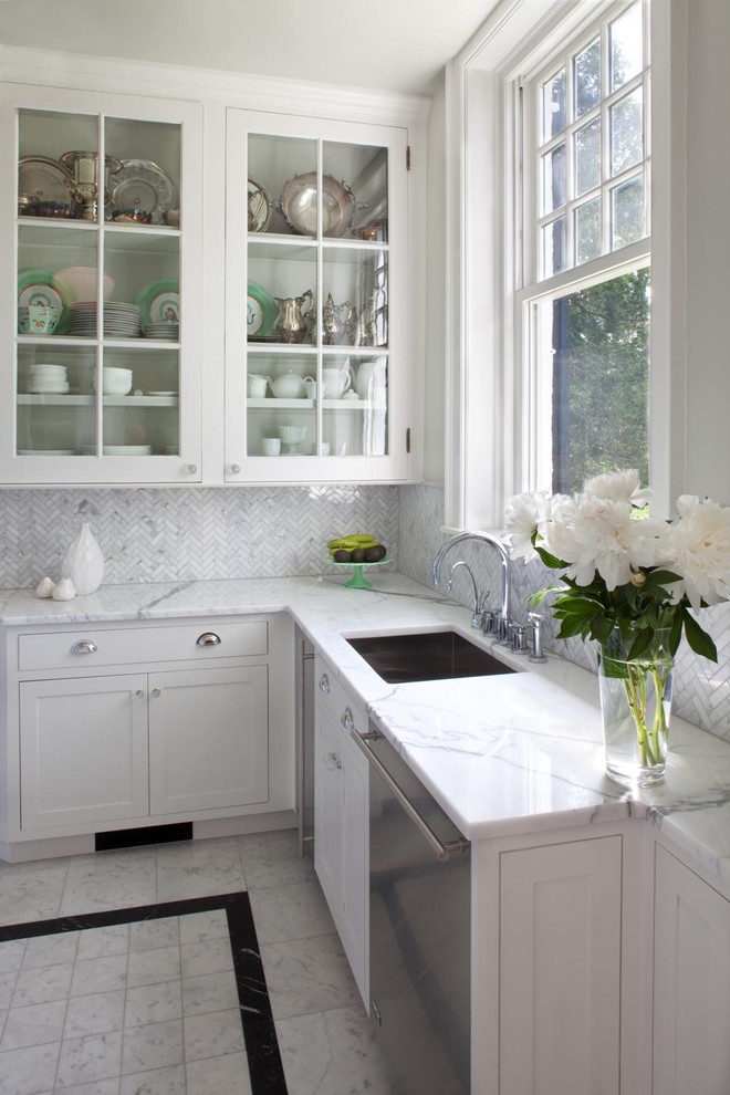 Inspiration for a traditional kitchen in Philadelphia with glass-front cabinets, stainless steel appliances, marble benchtops, a single-bowl sink, white cabinets, white splashback and marble splashback.